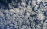 Высококучевые облака (AltocumulusAc)

Высококучевые облака представляют собой облачные пласты и гряды белого или серого цвета (или одновременно и того и другого). Это достаточно тонкие облака, более или менее затеняющие солнце. Пласты или гряды состоят из плоских валов, дисков, пластин, часто расположенных рядами. Кажущаяся ширина этих элементов в облаках на небесном своде 1-5o. В них возникают оптические явления - венцы. Для высококучевых облаков характерна иризация - радужная окраска краев облаков, направленных к солнцу. Иризация указывает на то, что высококучевые облака состоят из очень мелких однородных капель, как правило переохлажденных.

Высота 3-6 км
