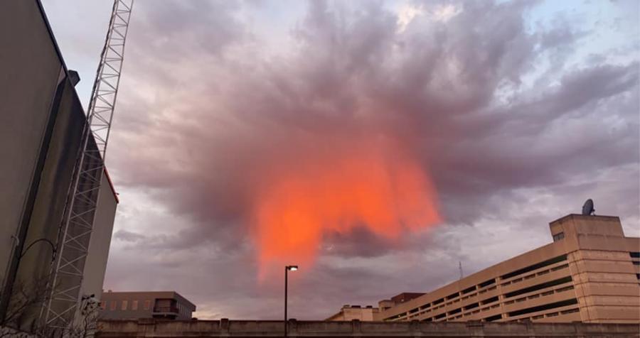This is a meteorological phenomenon known as Virga, when rain evaporates before reaching the ground. Here it is illuminated by the rays of the setting sun.